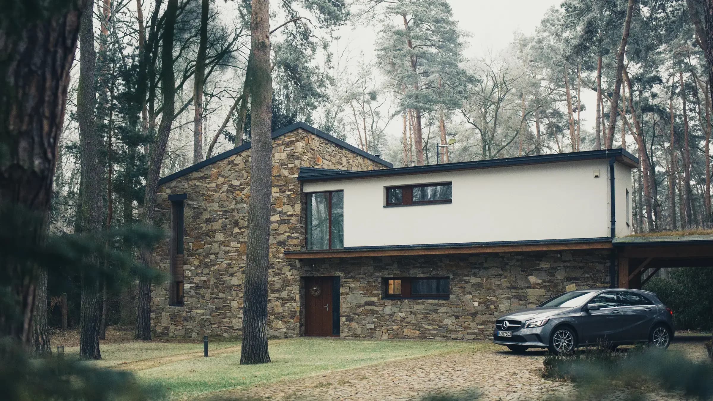 Rumah modern berdinding batu di tengah hutan pinus